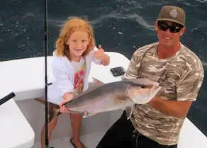 Young lady and first mate on Gecko charter holding out a nice amberjack.